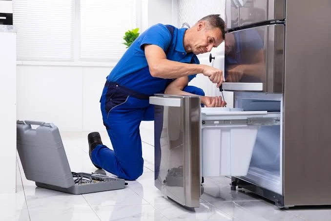 Technician working on a refrigerator freezer drawer